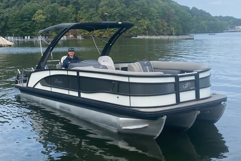 Slide: The Image of 2023 Barletta Lusso 25UCA pontoon boat on a serene lake. - 2