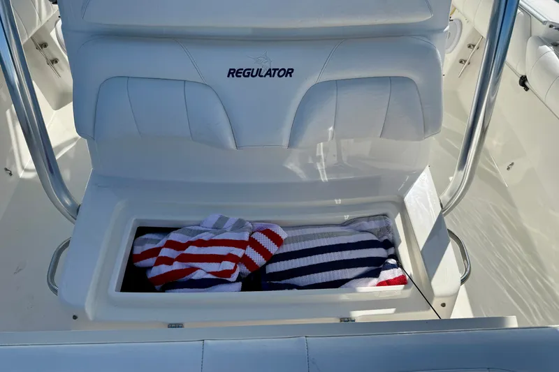 Slide: The Image of 2014 Regulator 28 Forward Seating boat with storage compartment and striped towels. - 24