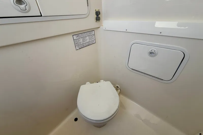 Slide: The Image of 2014 Regulator 28 Forward Seating boat interior with marine toilet and storage compartments. - 17