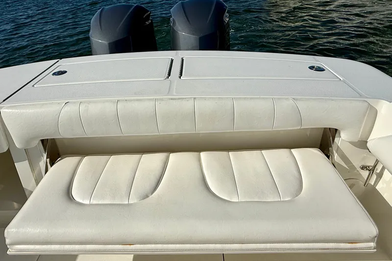 Slide: The Image of 2014 Regulator 28 Forward Seating boat with white cushioned bench and dual engines. - 32