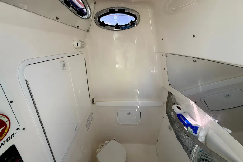 Slide: The Image of Interior cabin of a 2014 Regulator 28 Forward Seating boat, featuring storage and a small window. - 16