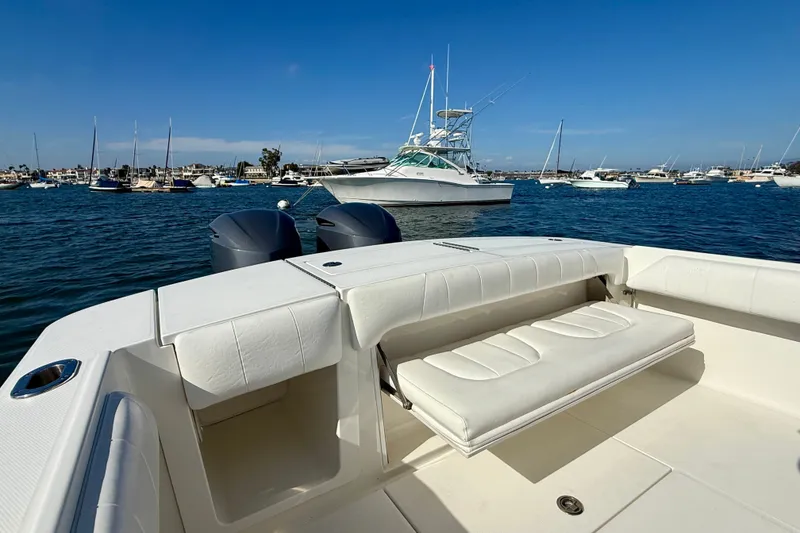 Slide: The Image of 2014 Regulator 28 Forward Seating boat on water, featuring spacious seating and dual engines. - 31
