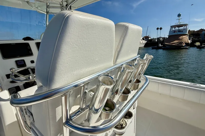 Slide: The Image of 2014 Regulator 28 Forward Seating boat interior with rod holders and helm, docked in marina. - 33