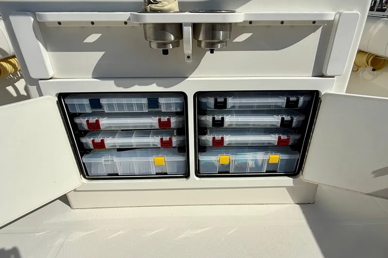 Slide: The Image of Storage compartments on a 2014 Regulator 28 Forward Seating boat, featuring organized tackle boxes. - 36