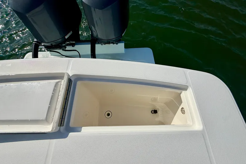 Slide: The Image of 2014 Regulator 28 Forward Seating boat with open storage compartment and dual engines. - 26