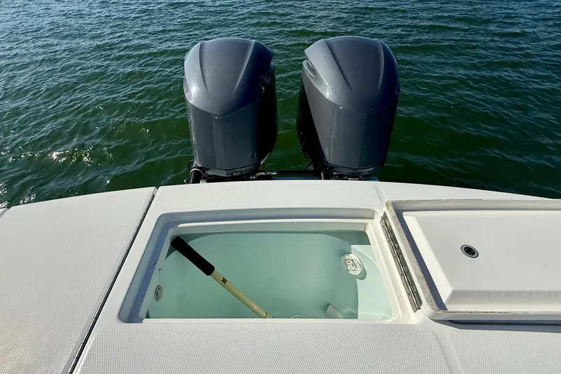 Slide: The Image of 2014 Regulator 28 Forward Seating boat with dual outboard motors on water. - 25