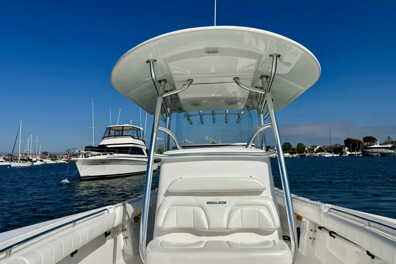 Slide: The Image of 2014 Regulator 28 Forward Seating boat on calm water, with clear blue sky. - 15