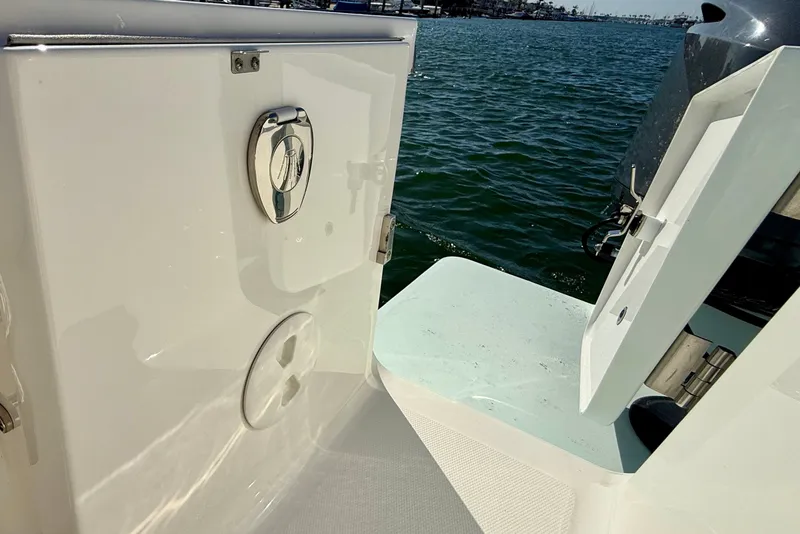 Slide: The Image of 2014 Regulator 28 Forward Seating boat with open hatch, docked by the water. - 28