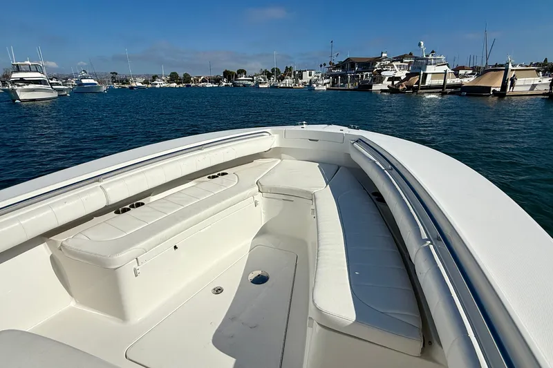 Slide: The Image of 2014 Regulator 28 Forward Seating boat in marina, showcasing spacious seating and scenic harbor view. - 29