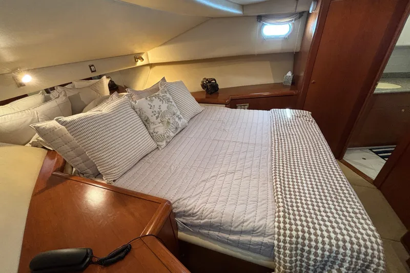 Slide: The Image of Luxurious 1996 Queenship yacht bedroom with cozy bedding and elegant wood finishes. - 13