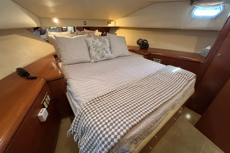 Slide: The Image of Cozy bedroom interior of a 1996 Queenship yacht with elegant bedding and wooden accents. - 11