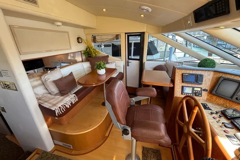 Slide: The Image of Luxurious 1996 Queenship yacht interior with plush seating, wooden helm, and modern navigation equipment. - 20