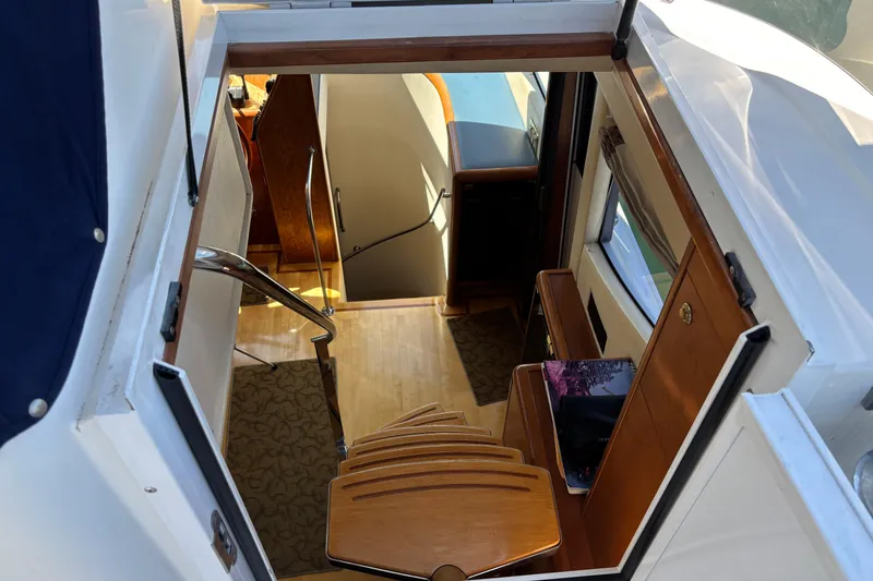 Slide: The Image of Interior view of a 1996 Queenship yacht, featuring wooden stairs and elegant design. - 30