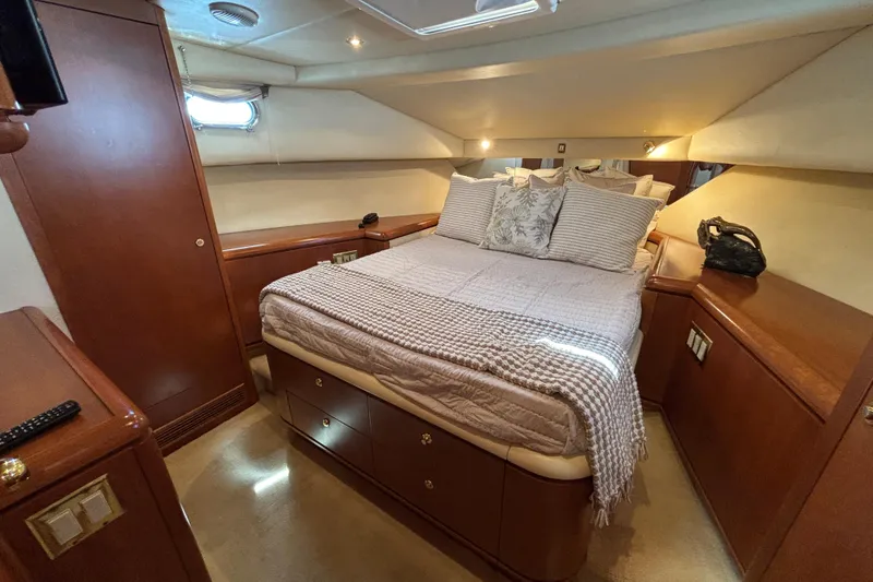 Slide: The Image of Luxurious 1996 Queenship yacht bedroom with elegant wood furnishings and cozy bedding. - 12
