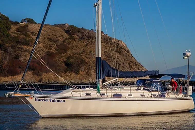 Slide: The Image of Sailboat "Harriet Tubman," Caliber 40, 2002 model, anchored near rocky shoreline. - 1