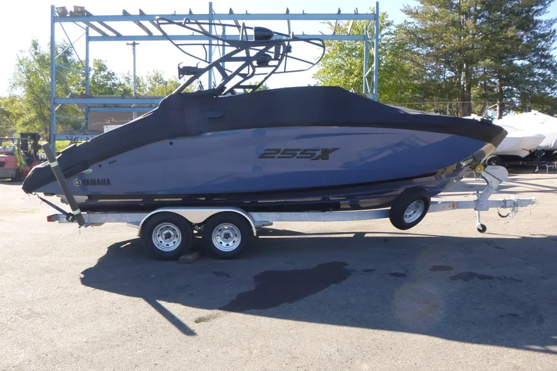 The Image of 2024 Yamaha Boats 255XD on trailer, parked outdoors, side view. - 1