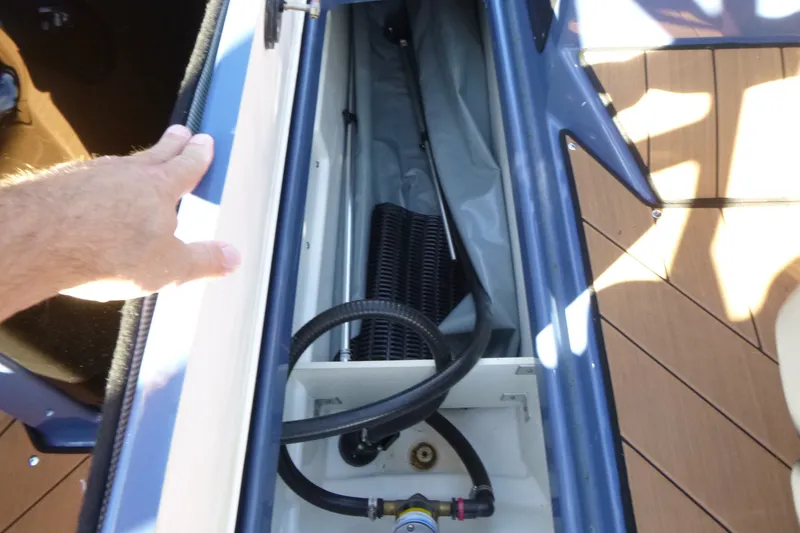 Slide: The Image of 2024 Yamaha Boats 255XD storage compartment with hand opening hatch. - 15