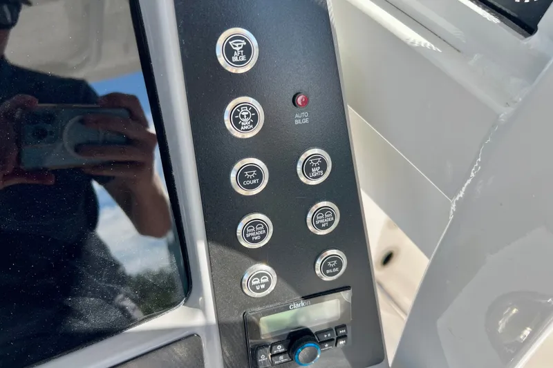 Slide: The Image of Control panel of 2027 Robalo R250 Center Console boat with various switches and buttons. - 16