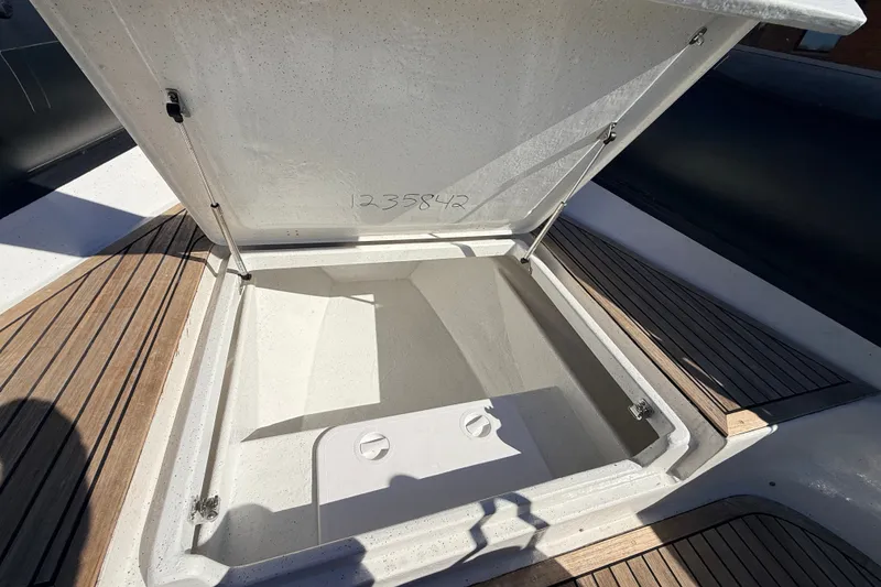 Slide: The Image of Open storage compartment on 2011 Protector Tauranga 38 boat with wooden deck. - 20