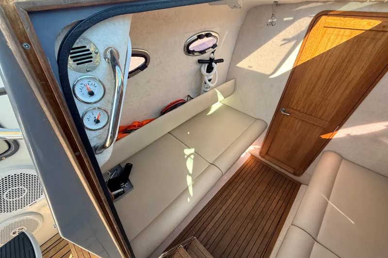 Slide: The Image of Interior of 2011 Protector Tauranga 38 boat with beige seating and wooden accents. - 38
