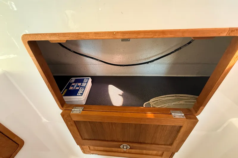 Slide: The Image of Wooden cabinet on a 2011 Protector Tauranga 38 boat, containing a first aid kit. - 45