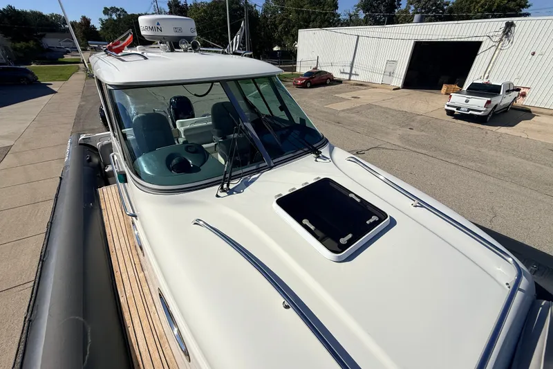 Slide: The Image of 2011 Protector Tauranga 38 boat with Garmin radar, parked outdoors. - 16