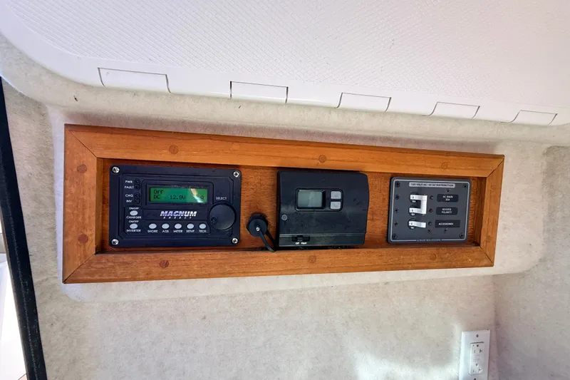 Slide: The Image of Control panel of a 2011 Protector Tauranga 38 boat with various switches and displays. - 27