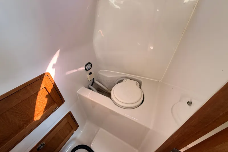Slide: The Image of Compact marine bathroom in 2011 Protector Tauranga 38 boat, featuring a toilet and wooden cabinetry. - 42