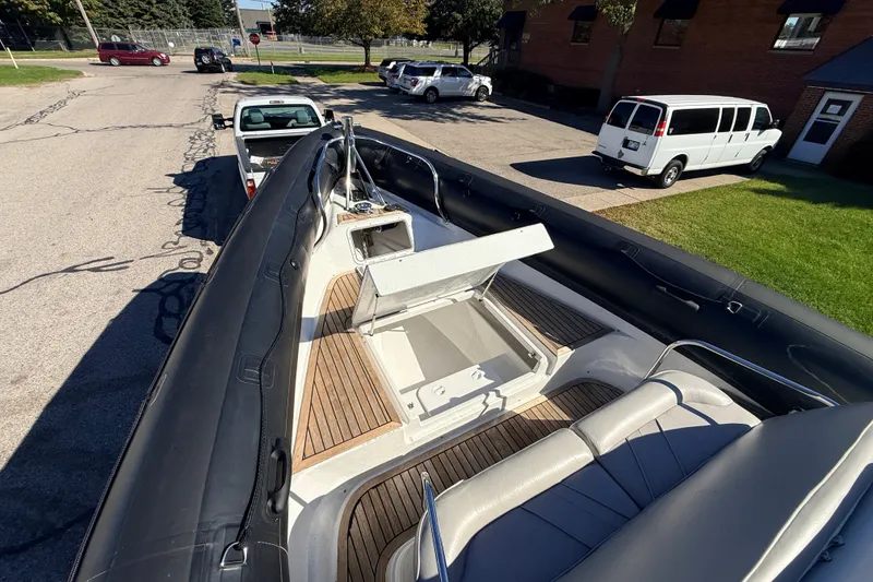 Slide: The Image of 2011 Protector Tauranga 38 boat on trailer, open storage compartment, parked on street. - 14