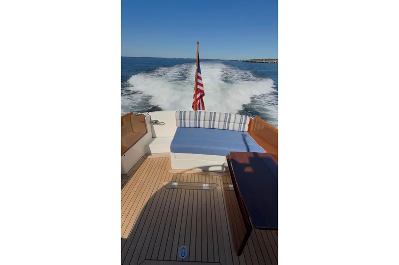 Slide: The Image of Hinckley Picnic Boat 37 MKIII cruising, featuring elegant deck and American flag, 2014 model. - 13