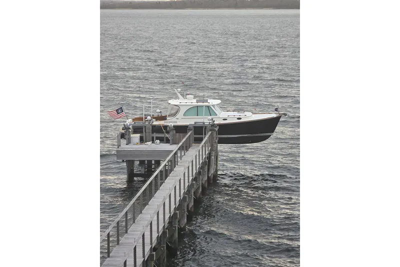 Slide: The Image of 2014 Hinckley Picnic Boat 37 MKIII docked on a calm waterfront. - 16
