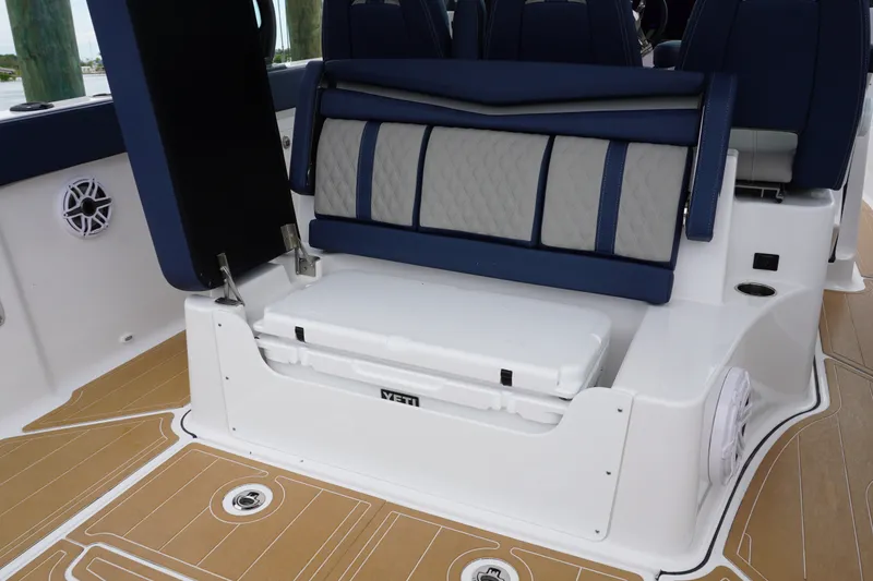 Slide: The Image of 2027 Monterey Elite 34 OB boat interior with cushioned seating and integrated cooler. - 18