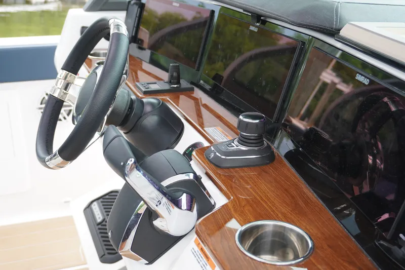 Slide: The Image of 2027 Monterey Elite 34 OB helm with modern controls and sleek wood finish. - 25