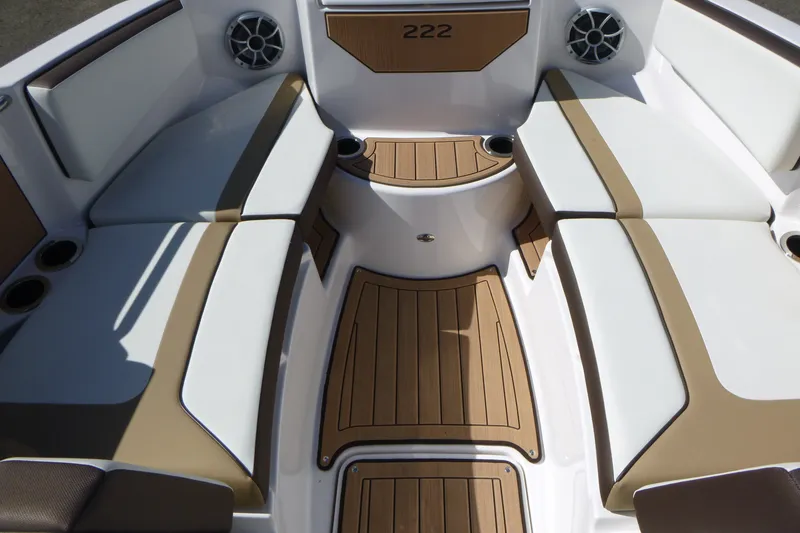 Slide: The Image of 2023 Yamaha Boats 222SD interior with tan and white seating, wood-style flooring. - 6