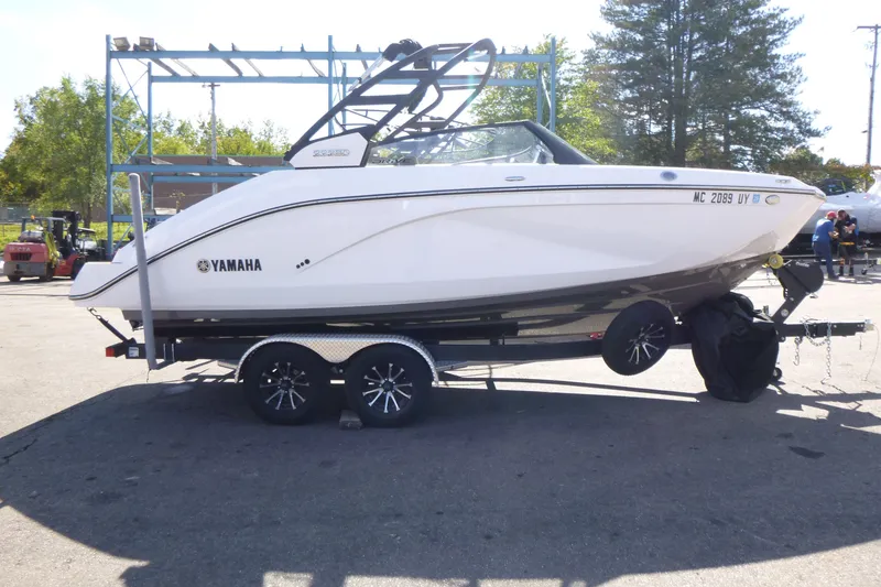 The Image of 2023 Yamaha Boats 222SD on trailer, parked outdoors in a sunny setting. - 1