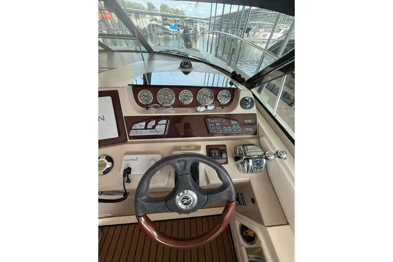 Slide: The Image of 2009 Sea Ray 350 Sundancer helm with steering wheel, gauges, and controls. - 25