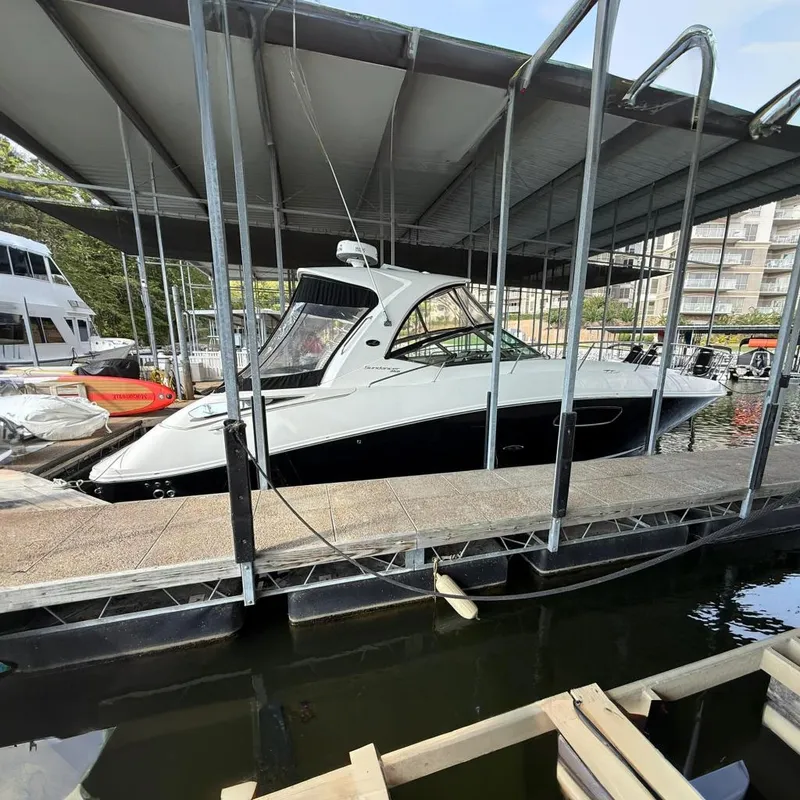 Slide: The Image of 2009 Sea Ray 350 Sundancer docked in a marina under a covered slip. - 16