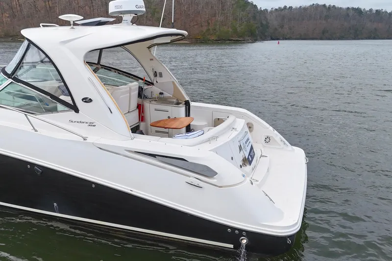 Slide: The Image of 2009 Sea Ray Sundancer 350 yacht on a serene lake with wooded shoreline. - 10