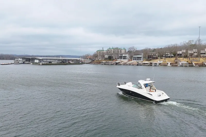Slide: The Image of 2009 Sea Ray Sundancer 350 cruising on a lake near waterfront homes and marina. - 15