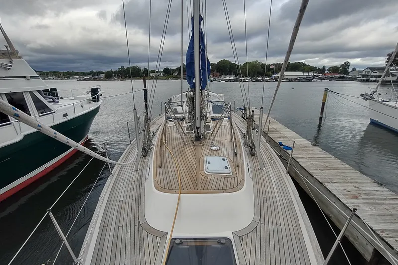 Slide: The Image of 2005 Hallberg-Rassy 43 sailboat docked at a marina under cloudy skies. - 19