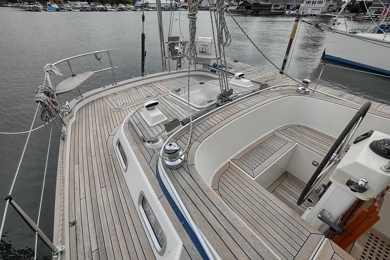 Slide: The Image of 2005 Hallberg-Rassy 43 sailboat deck with wooden finish, docked in a marina. - 21