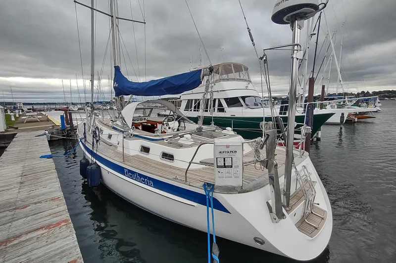 Slide: The Image of 2005 Hallberg-Rassy 43 sailboat docked at a marina under cloudy skies. - 15