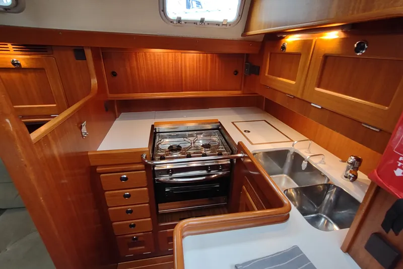 Slide: The Image of Luxurious 2005 Hallberg-Rassy 43 yacht kitchen with wood cabinetry and modern appliances. - 51