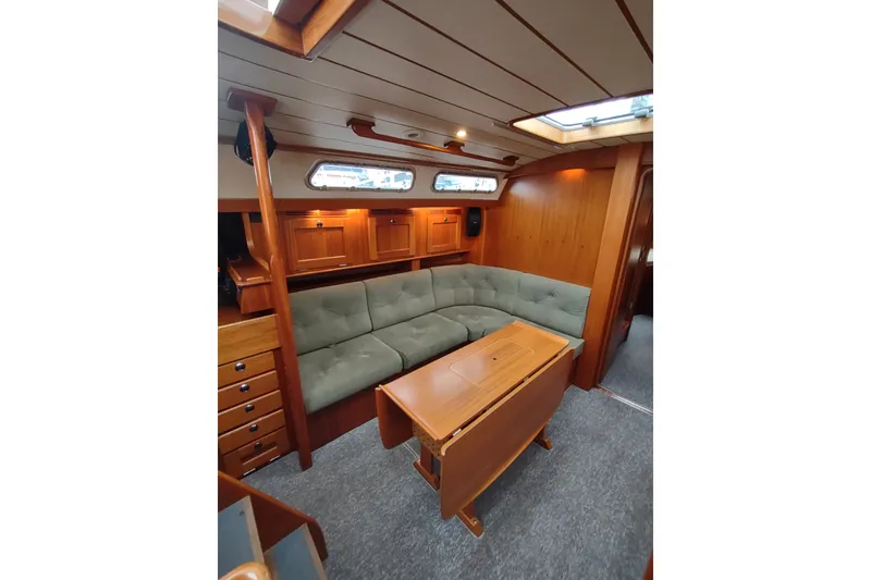 Slide: The Image of Luxurious 2005 Hallberg-Rassy 43 yacht interior with elegant wood finish and cozy seating area. - 41