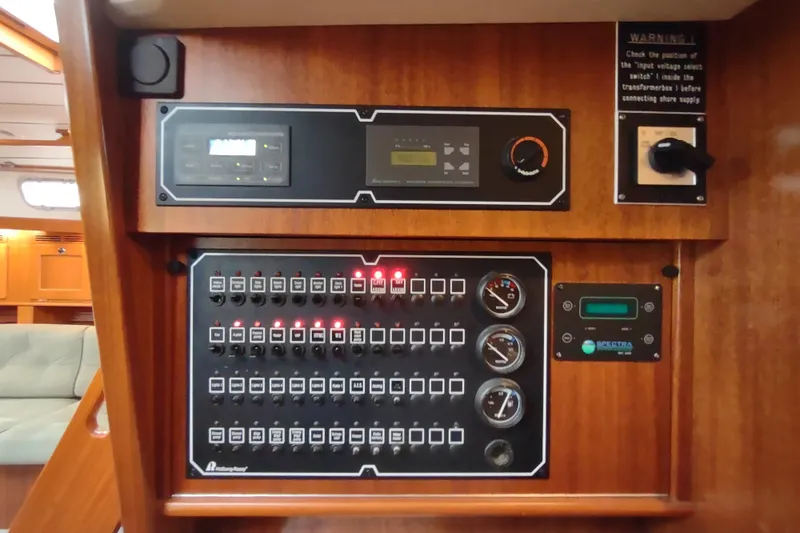 Slide: The Image of Electrical control panel on a 2005 Hallberg-Rassy 43 yacht, featuring switches and gauges. - 64