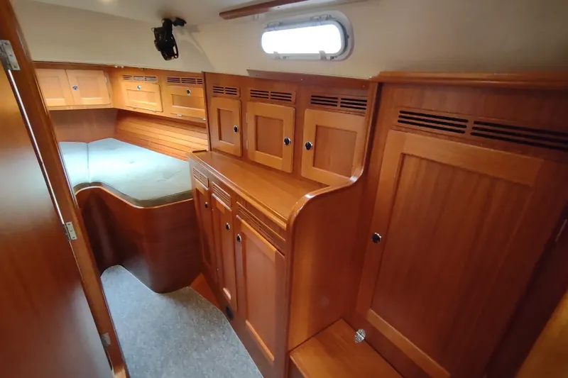 Slide: The Image of Interior of 2005 Hallberg-Rassy 43 sailboat with wooden cabinetry and cozy sleeping area. - 44