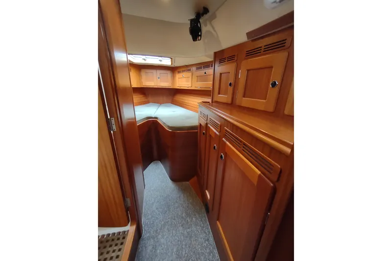 Slide: The Image of Interior of 2005 Hallberg-Rassy 43 yacht with wooden cabinetry and cozy sleeping area. - 45