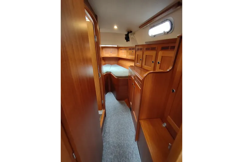 Slide: The Image of Interior of 2005 Hallberg-Rassy 43 yacht with wooden cabinetry and cozy sleeping area. - 43
