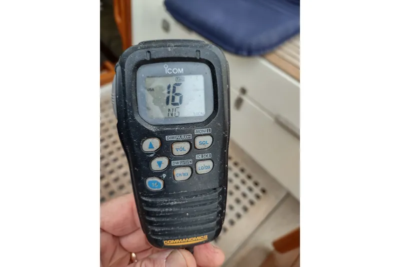 Slide: The Image of Hand holding Icom marine radio on Hallberg-Rassy 43 yacht, model year 2005. - 27