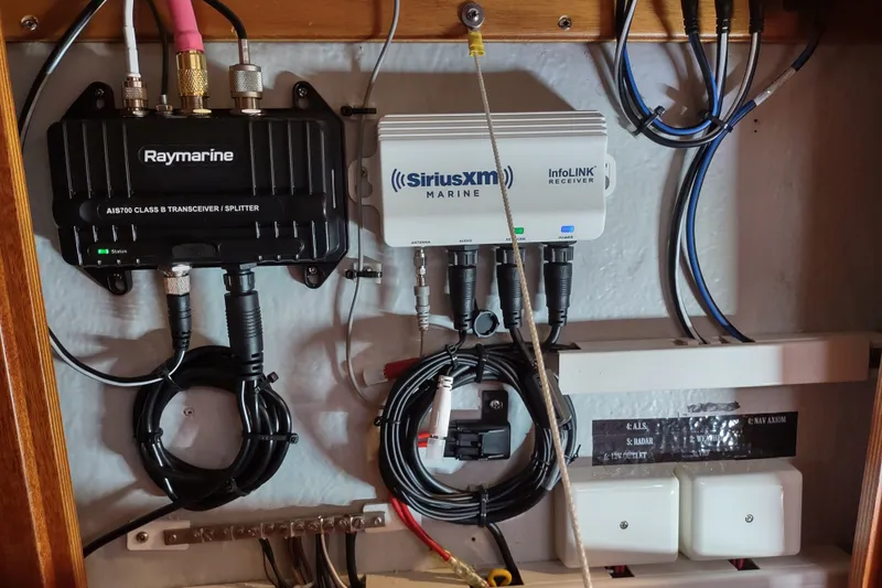Slide: The Image of Marine electronics setup on a 2005 Hallberg-Rassy 43, featuring Raymarine and SiriusXM devices. - 62